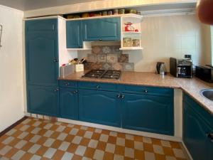 una cucina con armadi blu e pavimento a scacchi di De Viersprong a Laren