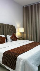 ein Schlafzimmer mit einem großen Bett und einer Lampe in der Unterkunft فيلا بشاطئ خاص ومسبح in Durrat Al-Arus