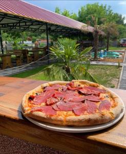 une pizza assise sur une table en bois dans l'établissement Villa Tino Omorani, à Veles