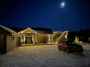 un coche aparcado delante de una casa por la noche en Lakefront Villa, exclusive leisure property near Vrådal Golf, Straand Summerland & Panorama Ski center en Vradal