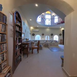 a living room with an archway and a dining room at Alexander Lodge in Siwa