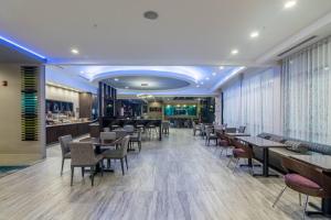 SpringHill Suites by Marriott Oklahoma City Downtown في مدينة اوكلاهوما: مطعم بطاولات وكراسي وبار