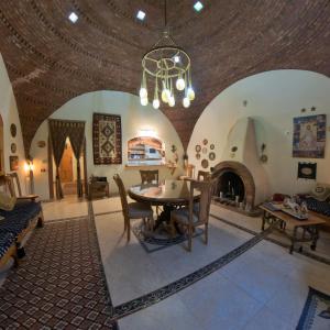 a dining room with a table and a fireplace at Alexander Lodge in Siwa