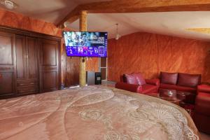 um quarto com uma cama grande e uma televisão em Chambre familiale em Aït Mouloud