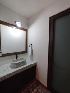 a bathroom with a sink and a mirror and a door at Lidia Anturios in Oaxaca City