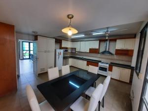 a kitchen with a black table and white chairs at MODERNA x 11 Pax in Mendoza