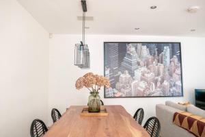 a dining room table with chairs and a painting on the wall at Spectacular Mews House in Holland Park in London