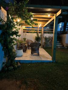a patio with two chairs and a table at night at Pousada Vielas do Rosa - centrinho da praia do rosa in Praia do Rosa