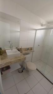 un bagno bianco con lavandino e WC di Residencial Acácias Guarajuba a Camassari
