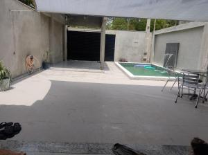 a patio with a table and chairs next to a pool at Casa de Praia Lado Sul in Guriri