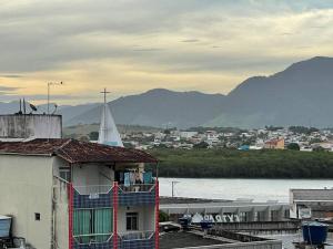 Blick auf eine Stadt mit Fluss und Kirche in der Unterkunft Quarto e sala 100 mts da praia in Guarapari