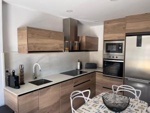 a kitchen with stainless steel appliances and wooden cabinets at PEÑISMAR AZAHAR in Peniscola