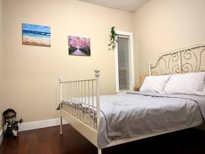 1 dormitorio con cama blanca y ventana en Private Guest Suite With Backyard, en Burnaby