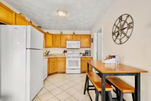 a kitchen with a table and a white refrigerator at Lake Winnisquam 1 Bedroom Condo with Lake Views in Tilton