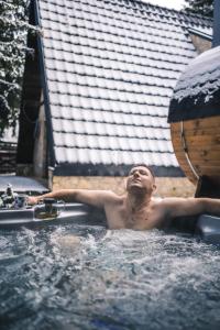 a man is in a bath tub in a swimming pool at Kežman Mountain Houses in Kopaonik