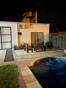 a patio with a bench and a swimming pool at night at Hospedaje la Maruca in Concordia
