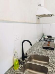 a kitchen counter with a sink and a stove at Hospedaje la Maruca in Concordia