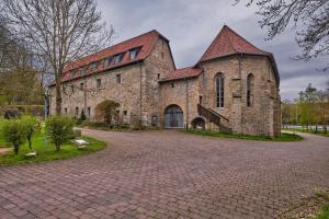 un gran edificio de ladrillo con techo rojo en Kloster Cornberg, 