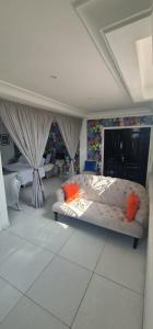 ein Schlafzimmer mit einem großen Bett mit orangefarbenen Kissen in der Unterkunft Greystone Mansion in Accra
