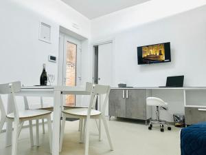 una sala da pranzo bianca con tavolo e sedie bianchi di Casa Vacanze San Giovanni a Potenza