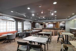 a restaurant with tables and chairs and a bar at SpringHill Suites by Marriott Williamsburg in Williamsburg