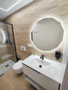 a bathroom with a white sink and a mirror at Apartamentos Centro Oviedo Caveda in Oviedo