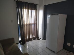 a living room with a refrigerator and a window at Apartamento Biarritz in São Luís