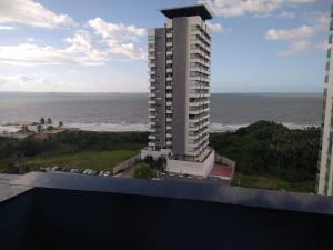 a view of a building with the ocean in the background at Apartamento Biarritz in São Luís