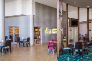 una sala da pranzo con tavoli, sedie e TV di SpringHill Suites by Marriott Kennewick Tri-Cities a Kennewick