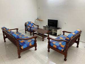 uma sala de estar com três cadeiras e uma mesa em Go Holiday Taiping Homestay em Simpang