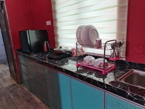 a kitchen counter with a sink and a tv at VILLA HAJAH RUGAYAH MUAR in Muar +6 photos
