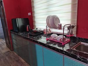 - un comptoir de cuisine avec évier et une télévision dans l'établissement VILLA HAJAH RUGAYAH MUAR, à Muar