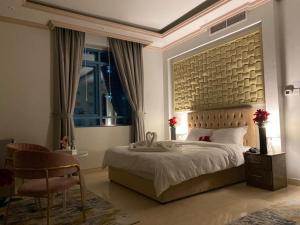 a bedroom with a large bed and a chair at Bareen Hotel in Ajman 