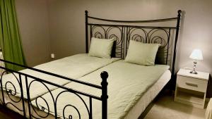 - une chambre dotée d'un lit noir avec des draps et des oreillers blancs dans l'établissement 1925 Upstairs Ljungby, à Ljungby