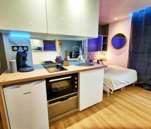 una cocina con fregadero y una cama en una habitación en Hamac chic vue mer. en Berck-sur-Mer