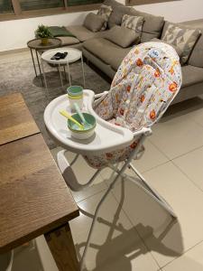 a high chair with a bowl on it in a living room at Vibe Place in Netanya
