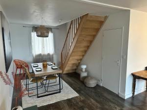 a living room with a table and a staircase at Le charmeur des dames proche Loire à vélo in La Ville-aux-Dames