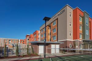 a building with a tennis court in front of it at Residence Inn Sacramento Davis in Davis