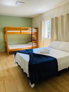 a bedroom with two bunk beds and a window at Maré Leve Maresias in Maresias