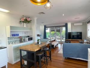 a kitchen and living room with a table and a couch at Romantic Escape/ Cozy Delight in Brisbane