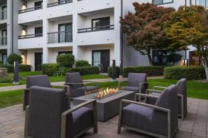 a patio with chairs and a fire pit in front of a building at Courtyard by Marriott Bakersfield in Bakersfield