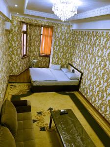 1 dormitorio con cama y lámpara de araña en Однокомнатная в Душанбе en Dushanbe