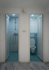 uma casa de banho com um WC e uma cabina de duche em vidro. em Sneza em Podgorica