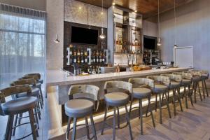 un bar con una fila de taburetes en una habitación en SpringHill Suites by Marriott Chattanooga North/Ooltewah, en Ooltewah