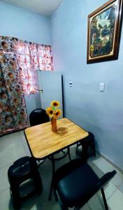 einen Tisch mit Stühlen und eine Vase mit Blumen darauf in der Unterkunft Departamento Pacífico in Mazatlán