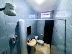 niebieska łazienka z toaletą i umywalką w obiekcie Departamento Pacífico w mieście Mazatlán