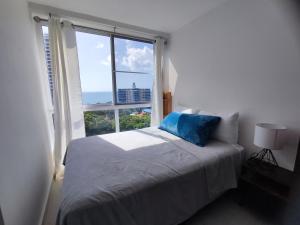 sypialnia z łóżkiem i dużym oknem w obiekcie Playa Coronado, Apartamentos con vista al mar w mieście Las Lajas