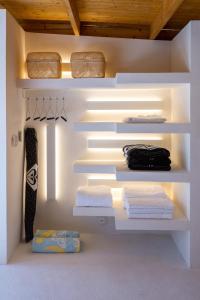 a white closet with white shelves and towels at Casa SANA in Puerto Escondido