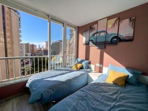 a bedroom with a bed and a window with a car on the wall at Karola cosy in Benidorm