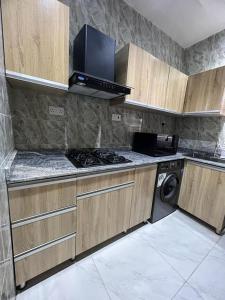 Oluyole Apartments Ibadan في إيبادان: مطبخ مع موقد وغسالة ملابس